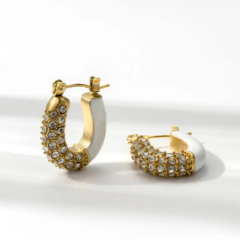Gold hoop earrings with embedded stones on a white background